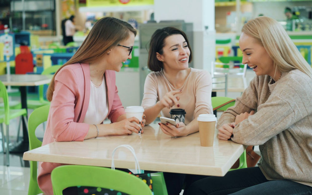 Grupo pequeño conversando y riendo alrededor de una mesa